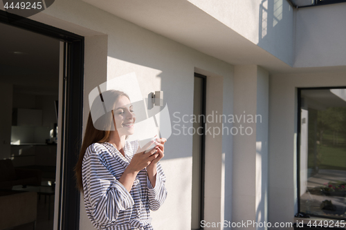 Image of woman in a bathrobe enjoying morning coffee