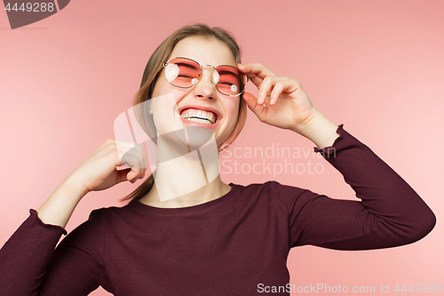 Image of Woman smiling with perfect smile and white teeth on the pink studio background