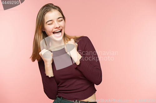 Image of Woman joyfully screams white teeth on the pink studio background