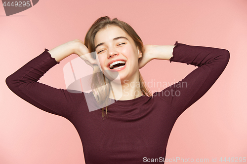 Image of Woman smiling with perfect smile and white teeth on the pink studio background