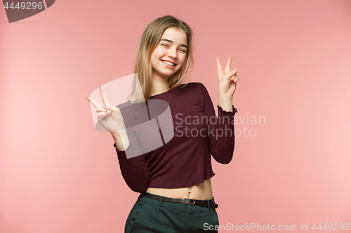 Image of Woman smiling with perfect smile and white teeth on the pink studio background and looking at camera