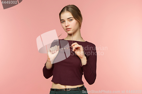 Image of Woman standing and very cute looking at camera on the pink studio background
