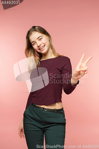 Image of Woman smiling with perfect smile and white teeth on the pink studio background and looking at camera