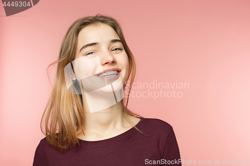 Image of Woman smiling with perfect smile and white teeth on the pink studio background and looking at camera