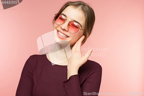 Image of Woman smiling with perfect smile and white teeth on the pink studio background