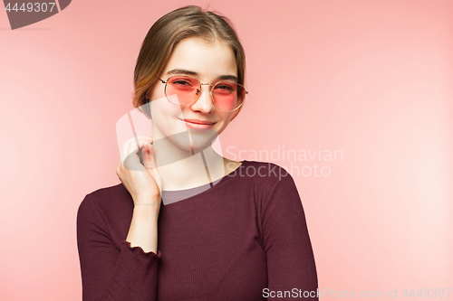 Image of Woman smiling with perfect smile and white teeth on the pink studio background and looking at camera