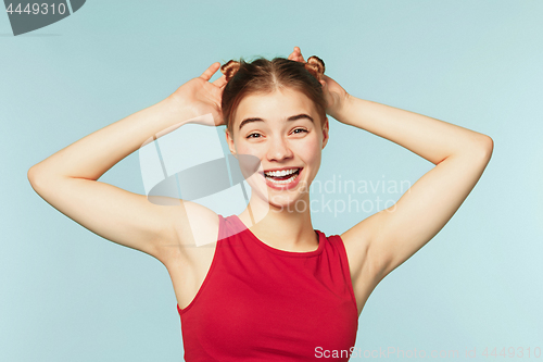 Image of Woman smiling with perfect smile on the blue studio background