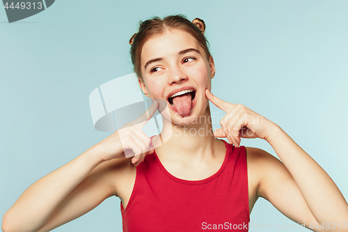 Image of Woman smiling with perfect smile on the blue studio background