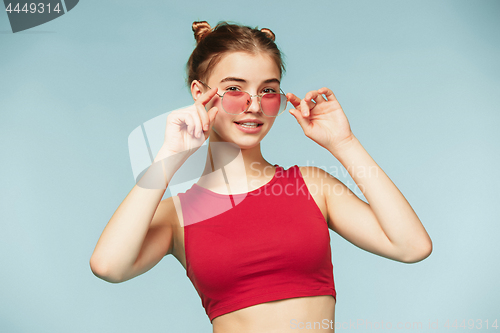 Image of Woman standing and very cute looking at camera on the blue studio background