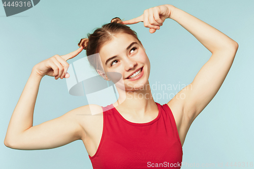 Image of Woman smiling with perfect smile on the blue studio background