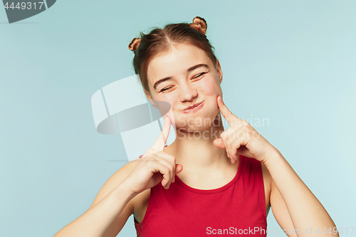 Image of Woman smiling with perfect smile on the blue studio background