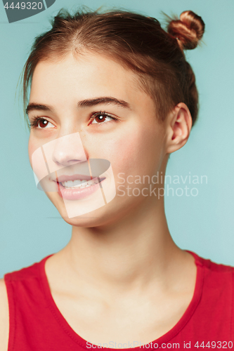 Image of Woman smiling with perfect smile on the blue studio background and looking at camera