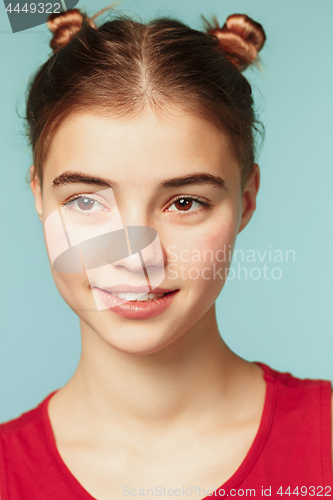 Image of Woman smiling with perfect smile on the blue studio background and looking at camera