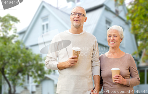 Image of happy senior couple with coffee over living house