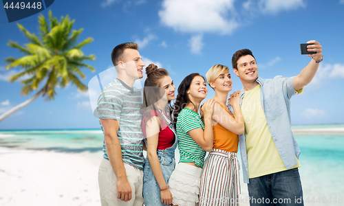 Image of friends taking selfie by smartphone over beach