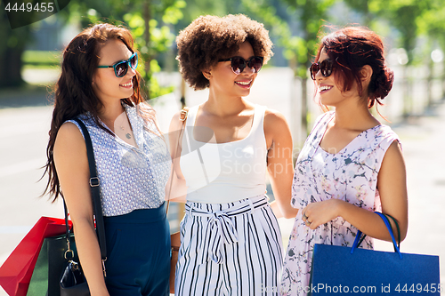 Image of happy women with shopping bags in city