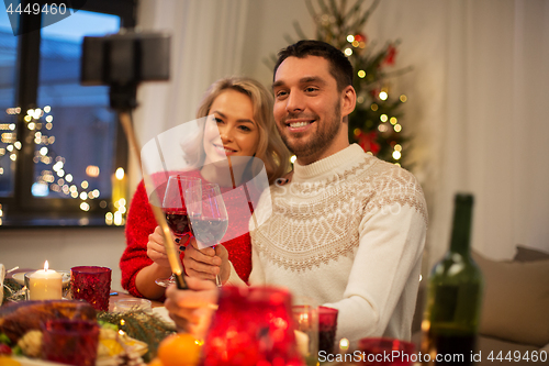 Image of couple taking picture by selfie stick at christmas