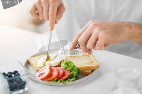 Image of close up of man having toasts for breakfast