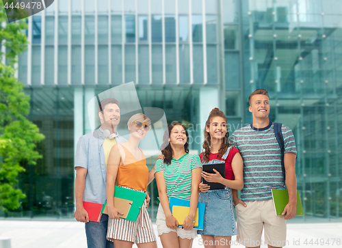 Image of students with books and folders over modern school