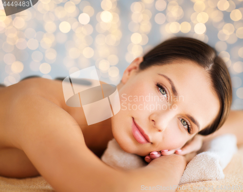 Image of beautiful woman having hot stone therapy at spa