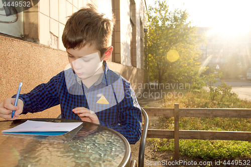 Image of Boy doing homework outdoors