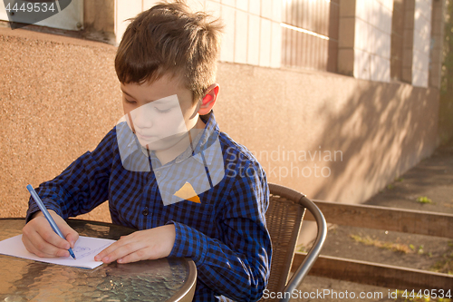 Image of Boy doing homework outdoors