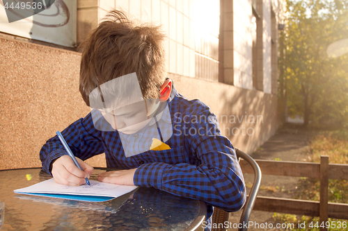 Image of Boy doing homework outdoors