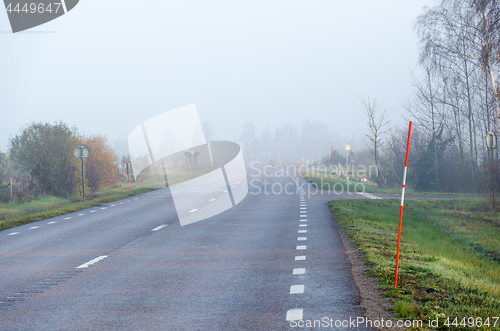 Image of Misty road with snow stakes