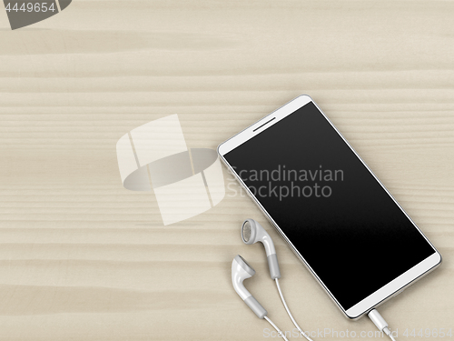 Image of White smartphone and earphones on wood background