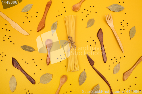 Image of Wooden utensils, pasta and spices flat lay composition