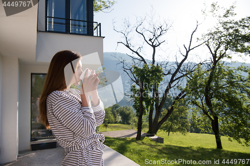 Image of woman in a bathrobe enjoying morning coffee