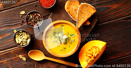 Image of Pumpkin soup with bread on chopping board