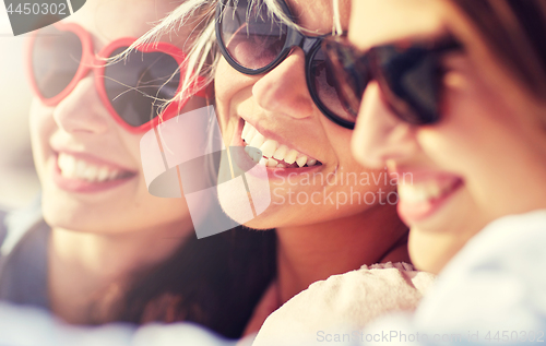 Image of group of smiling women taking selfie on beach