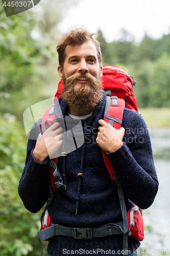 Image of bearded traveler with backpack in woods