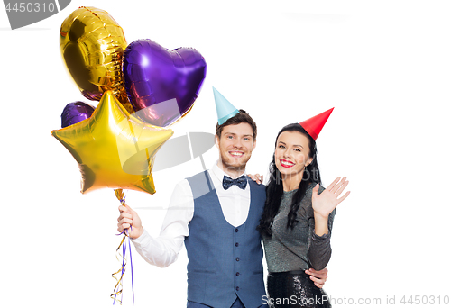 Image of happy couple with party caps and balloons