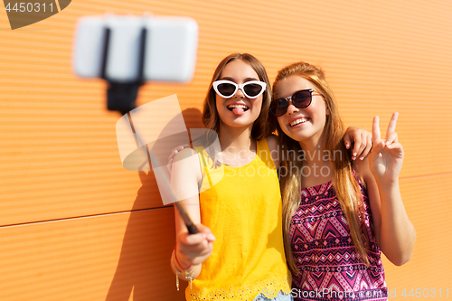 Image of teenage girls taking picture by selfie stick