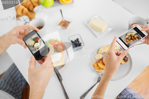 Image of close up of couple with smartphones at breakfast