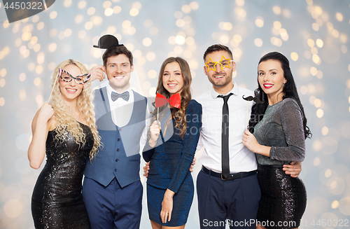 Image of happy friends with party props posing