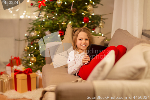 Image of smiling girl with tablet pc at christmas home