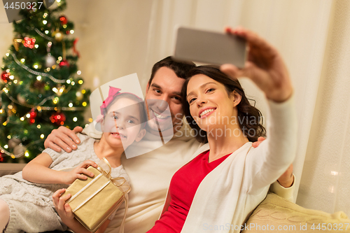 Image of happy family with christmas present at home