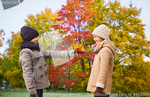 Image of kids with autumn maple leaves over park background