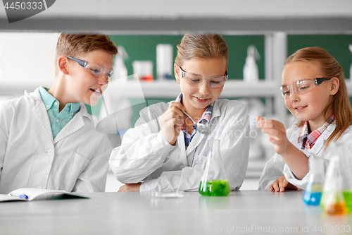 Image of kids with test tube studying chemistry at school