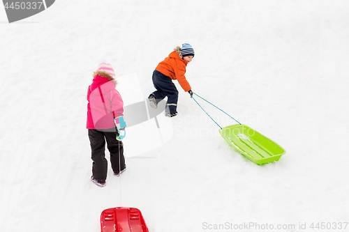 Image of kids with sleds climbing snow hill in winter