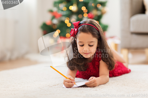 Image of little girl writing christmas wish list at home
