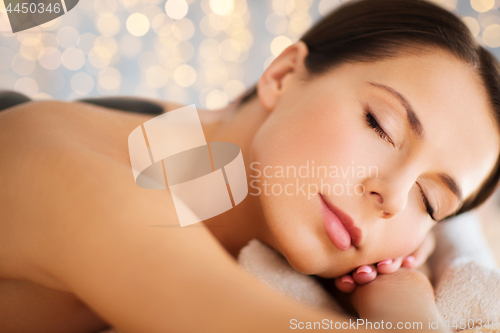 Image of beautiful woman having hot stone therapy at spa