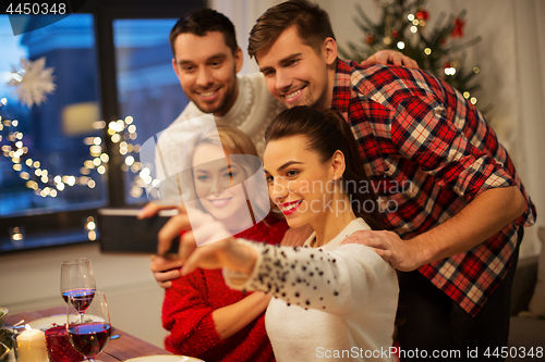 Image of friends taking selfie at christmas dinner