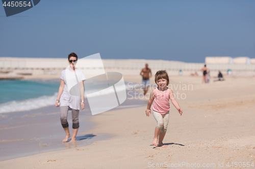 Image of mother and daughter running on the beach