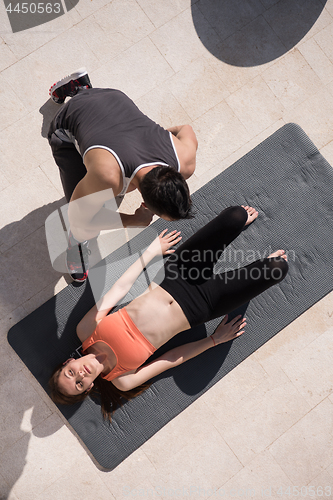 Image of woman with personal trainer doing morning yoga exercises top vie