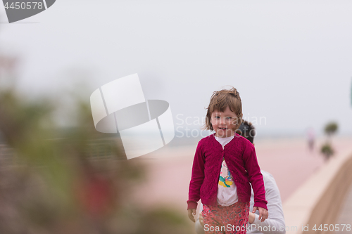 Image of mother and cute little girl on the promenade by the sea