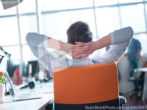 Image of young businessman relaxing at the desk